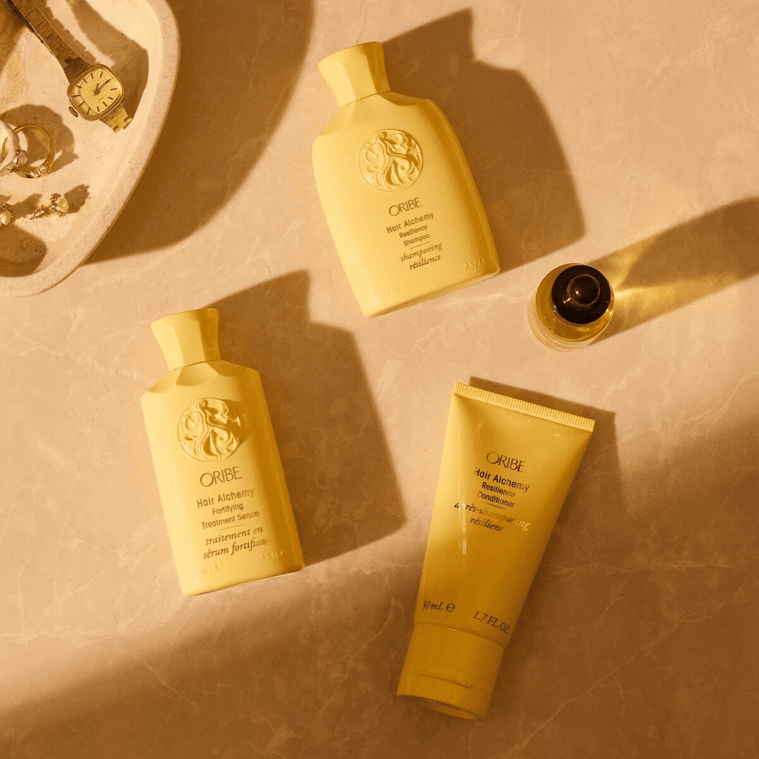 Hair Alchemy products on marble surface with warm lighting.