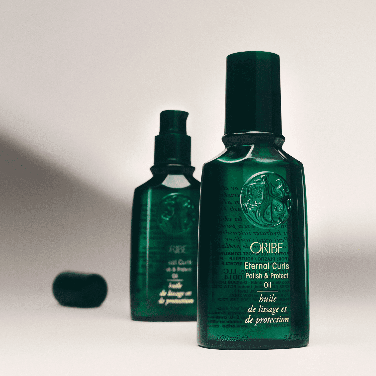 Oribe Eternal Curls hair oil bottles with embossed design on a neutral background.